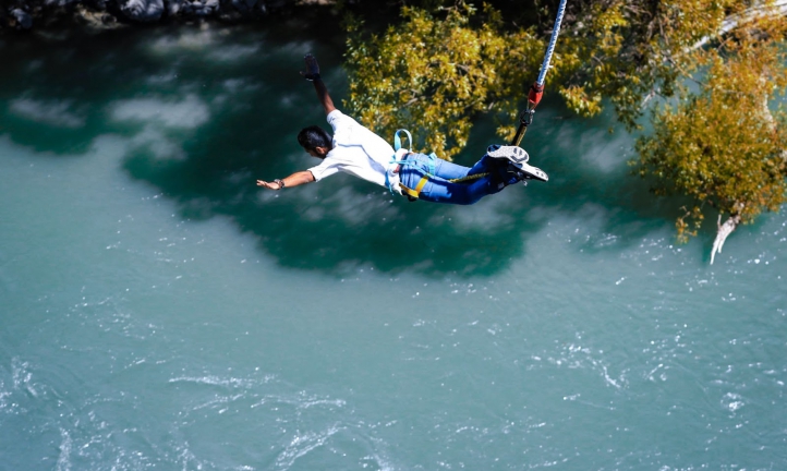 Man bungee jumping over water