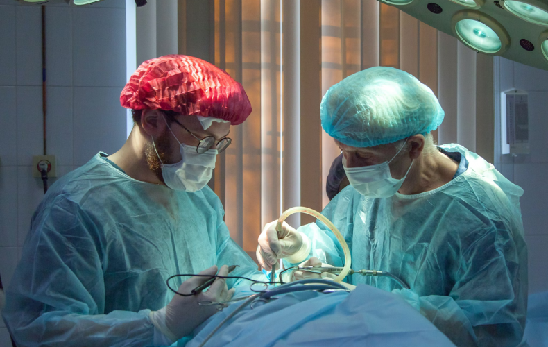 Two doctors performing surgery on a patient