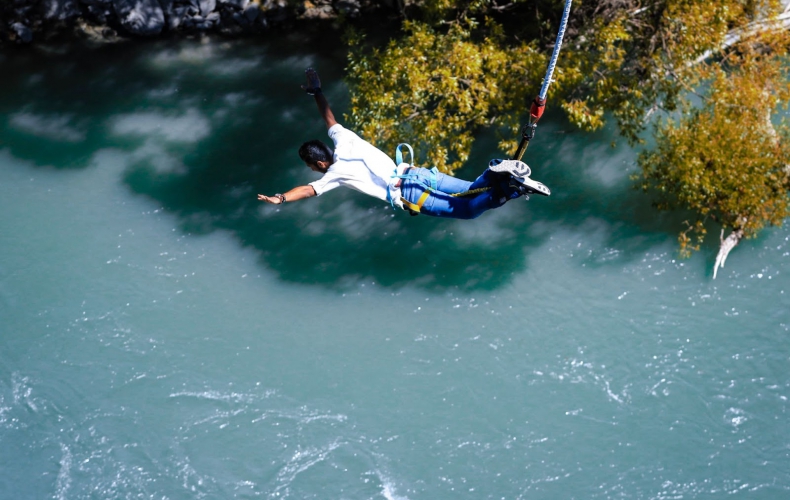 Man bungee jumping over water